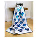 The completed Scrappy Love quilt finished and staged on an antique sewing machine. 