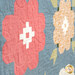 An angled super close up on two of the patchwork flowers, demonstrating fabric print and color details as well as top quilting effects.