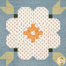 A head-onsuper close up on a soft white and yellow patchwork flower as well as four green arrow blocks, demonstrating fabric print and color details as well as top quilting effects.