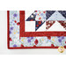 A super close up of a corner of the table runner showing the border fabric, binding, and top stitching details.