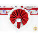 A top down of one of the fanned out napkins, showing the scarlet red fabric side, in a silver ring on a white plate. There is a matching table runner across the top of the image.
