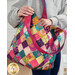 A model slips an item into the main section of the bag, showing details on the inside of the strap and colors of the outer fabric.