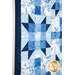 An angled shot of the right side of the quilt, showing the patchwork design, fabric print details, and top stitching effects.