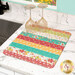 The completed Dry Idea's Kit colored in colorful florals from the In The Garden collection by Moda, set next to a sink with two wine glasses on top and surrounded by coordinating décor.  