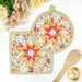 The completed Folded Hot Star Pads in orange, white and vermillion fabrics from the In The Garden collection by Moda, staged on a white table with coordinating decor.