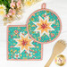 The completed Folded Hot Star Pads in orange, white and teal fabrics from the In The Garden collection by Moda, staged on a white table with coordinating decor.