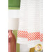A close up shot of the bottom orange and white striped fabric, a pink vase can be seen in the background.