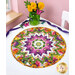 The completed Point of View Kaleidoscope Folded Star Table Topper, colored in vibrant magenta, yellow, orange, and green fabrics from the Dahlia Botanica collection by Wilmington Prints, staged on a white table with coordinating décor.