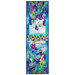The completed Iris in Bloom table runner, colored in bright cerulean, purple, and green fabrics from the Infatuation collection by Northcott Fabrics, isolated on a white background. 