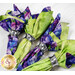 A close look at four napkins, colored in green and purple fabrics and fastened with a silver napkin ring.