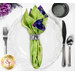 A top down shot of the napkin with the green side out, showcasing the texture print; the napkin is staged with a white plate, silverware, and matching cup.