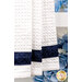A close up shot of the bottom dark blue fabric, blue hydrangeas can be seen in the background.