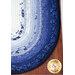 A top down shot of the completed Jelly Roll rug finished in dark blue, blue, and white fabrics. 