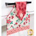 An angled close up on the top of the towel, showing details on the floral prints, tab, and fabric button.