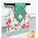 An angled close up on the top of the towel, showing details on the floral prints, tab, and fabric button.