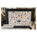 The front of the pattern with the finished cross stitch framed and surrounded by coordinating décor.