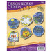 The DesignWorks craft kit featuring six Halloween-themed cross stitch ornaments, including a cat, a pumpkin, a ghost, a bat, a spider, and a trick or treat bag..