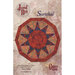The front of the Sundial pattern, showcasing the finished table topper on a mottled background.