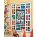 Colorful patchwork quilt featuring playful scenes and patterns, displayed on a wall in a children's room.