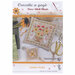 The completed Summer Basket cross stitch pattern staged with sunflowers and scissors. 