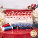A stack of the fabrics included in the Fat Eighth Bundle, with a stand and flowers and thread.