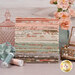 A stack of the fabrics included in the Dearly Beloved FQ Bundle, with glassware and flowers and jewelry and thread.