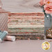 A stack of fabrics included in the F8 collection, with flowers and glassware and jewelry and thread.