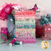 A stack of the fabrics included in the Floriori collection, with jars and flowers and a butterfly and thread.