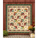 The completed Maisons de Patchwork Quilt colored in warm fabrics from the Pennyberry Farm collection by Henry Glass Fabrics, staged on a textured red barn wall with coordinating flowers and planters.