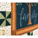 An angled close up on the quilt, showing fabric color and print details on a pinwheel block and the panel.