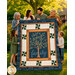 The completed Family Tree Patchwork Panel Quilt, colored in blue, cream, and brown fabrics from the Family Tree collection by Moda Fabrics, held aloft by a family in a sunny backyard.