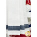 A close up shot of the bottom white and blue striped fabric, a patriotic gnome can be seen in the background.