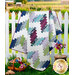 The completed Ridiculously Easy Jelly Roll Quilt in fabric from the Seaside Garden collection, staged on a white picket fence with wooden stool, cut flowers, and gardening gloves.
