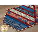 A close up on one end of the runner, showing details on the patriotic fabrics, staged with coordinating table settings and glass jars.