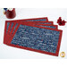 Four Self-Binding Placemats with a navy blue print featuring patriotic words and phrases, framed by a crimson border fabric, staged on a white table with coordinating décor.