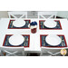 A white table staged with all four placemats and four coordinating table settings; coordinating flowers sit in the middle.