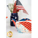 A close up on a patriotic bowl cozy next to a blue jar holding a small American flag.