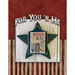 Completed and mounted cross stitch pattern of a figure with a dog and an American flag and the text "This land was made for you'n me.