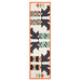 The completed Witches Feet table runner with a geometric design of witch legs and boots in orange, black, green, and cream, isolated on a white background.