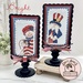 The two completed cross stitch projects of Sam and Betsy, set on light blue fabric and stitched with bright colors, displayed on a Paisleys and Polka Dots mount.