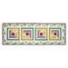 The completed table runner made with log cabin blocks of plum purple, ocher, and teal floral fabrics from the Renew collection, isolated on a white background. 