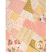 A close up on the patchwork of the quilt, demonstrating fabric color and print details as well as top quilting effects.