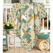 The completed Easy as ABC and 123 Quilt Kit colored in teal, cream, and ocher fabrics from the Renew collection by Riley Blake Designs, artfully draped over a porch railing and staged with coordinating décor.