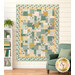 The completed Easy as ABC and 123 Quilt Kit colored in teal, cream, and ocher fabrics from the Renew collection by Riley Blake Designs, displayed on a cream shiplap wall and staged with coordinating décor.