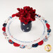 A shot of the topper staged with a patriotic vase and red flowers.