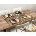 The completed Quail Run placemats, set on a wooden table with rustic décor and four place settings. 