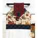 A close up shot of the top of the hanging towel, showing details on the floral prints and fabric button.