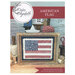 The front of the cross stitch pattern with the completed project framed and surrouend by coordinating décor. 