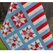 The completed quilt in vibrant red, white, and blue fabrics, draped to show form.