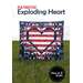 A quilt featuring a large heart design in red, white, and blue, set against a grassy background.